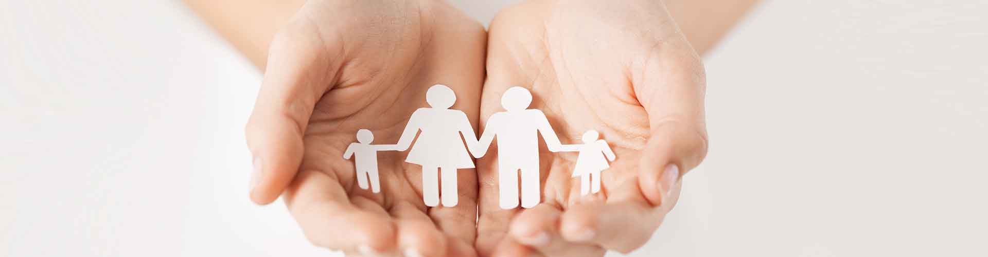 hands holding paper cutout of family